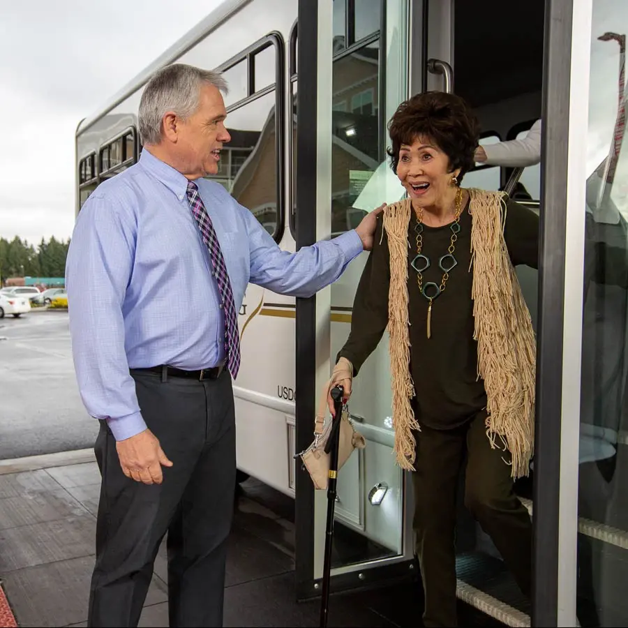 Fairview Estates man helping lady off bus